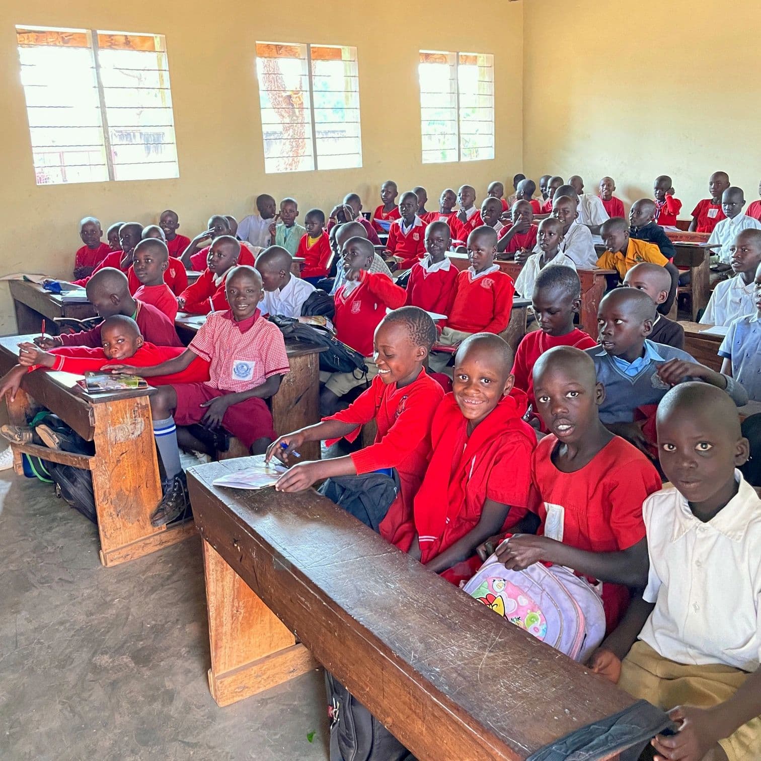 A classroom of students in red uniforms at one of our partner schools